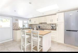 a kitchen with white cabinets and a kitchen island with stools at Spacious 2-bedroom property, minutes from city. in Dublin