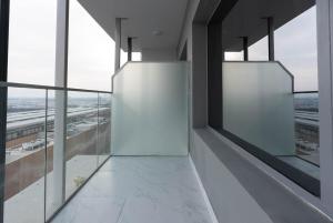 an empty building with large windows and a view of an airport at Cozy Studio In Oasis in Al Qurayyah