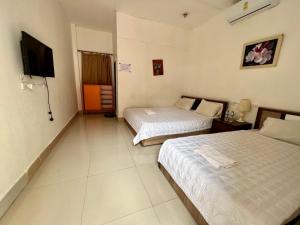 a hotel room with two beds and a flat screen tv at Vientiane Star Hotel in Vientiane