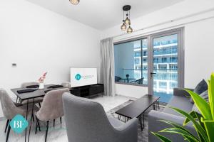 a living room with a table and chairs and a tv at Deluxe 1 Bedroom In Oasis in Abu Dhabi