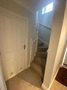 a stairway with a white door and stairs with a window at Cotswold Cottage in Cheltenham
