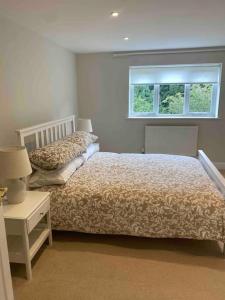 a bedroom with a bed and a window at Cotswold Cottage in Cheltenham