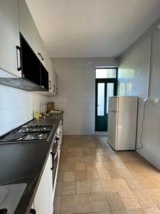 een keuken met een fornuis en een witte koelkast bij Rooms with shared kitchen "Milica" in Drvenik