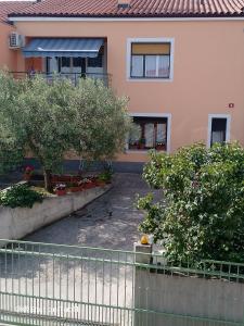 a house with trees and a fence in front of it at Apartma Bomar in Koper
