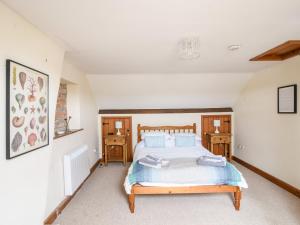 a bedroom with a bed and two night stands at Heron Cottage in Colyton