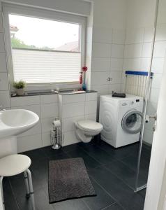 a bathroom with a washing machine and a washer at Nicky's Ferienhaus in Geeste