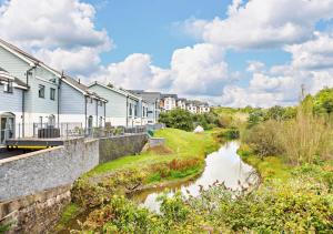 a river in front of houses and buildings at 2B Pen Y Bont in Abersoch