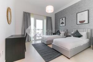 a bedroom with two beds and a large window at Golf Course View, Stylish 2 Bedroom in Al Qurayyah