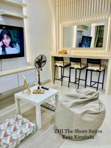 a living room with a tv and a table at ZHI The Shore Suites Kota Kinabalu in Kota Kinabalu