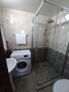a bathroom with a shower and a washing machine at chemi kera Chalet in Makho +54 photos