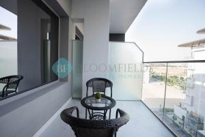 a table and chairs in a room with a window at Lavish Pool View Apartment in Abu Dhabi