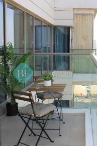 a balcony with a table and two chairs and a plant at Luxury 2 Bedroom In Reem Island in Abu Dhabi