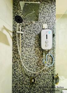 a shower in a tiled bathroom with a hose at ZHI The Shore Suites Kota Kinabalu in Kota Kinabalu