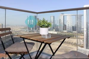 a table and chairs on a balcony with a view of a city at Luxury 2 Bedroom In Reem Island in Abu Dhabi