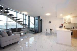 uma cozinha e sala de estar com uma escada numa casa em Luxury Duplex In Raha Lofts em Abu Dhabi