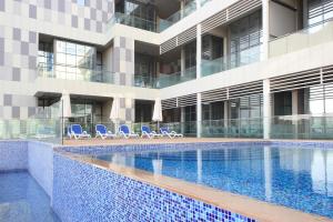 a swimming pool in front of a building at Luxury Duplex In Raha Lofts in Abu Dhabi