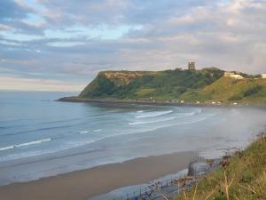 a view of a beach with a castle on a hill at Seaside Flat with Fast WiFi in Scarborough
