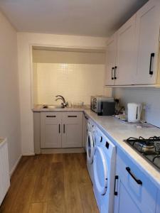 a kitchen with a washing machine and a sink at Seaside Flat with Fast WiFi in Scarborough