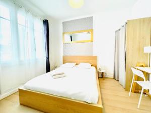 1 dormitorio con cama blanca, escritorio y ventana en F2 Golden Lounge, Hyper Centre, Parking en Nantes