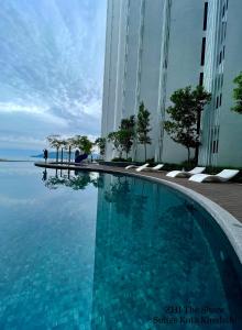 a swimming pool in front of a building at ZHI The Shore Suites Kota Kinabalu in Kota Kinabalu
