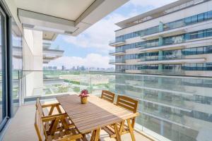 a balcony with a wooden table and chairs and a building at Modern 2 Br Maid's Room With Amazing View in Abu Dhabi