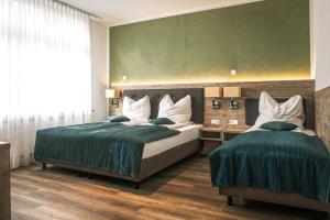 1 Schlafzimmer mit 2 Betten und einer grünen Wand in der Unterkunft VillaWie in Rheda-Wiedenbrück