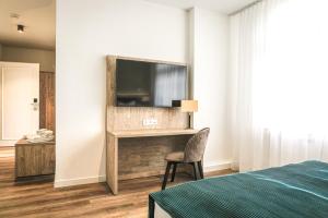 ein Schlafzimmer mit einem Bett und einem TV an der Wand in der Unterkunft VillaWie in Rheda-Wiedenbrück