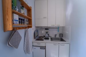 a small kitchen with white cabinets and a sink at Mathildedal private holiday apartment nr. 7 in Mathildedal