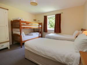a bedroom with two beds and a bunk bed at Garden Cottage No 2 in Keswick