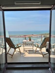 uma varanda com 2 cadeiras e uma mesa na varanda em Ribeira DIlhas Beach Apartment na Ericeira