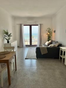 埃里塞拉的住宿－Ribeira DIlhas Beach Apartment，客厅配有沙发和桌子