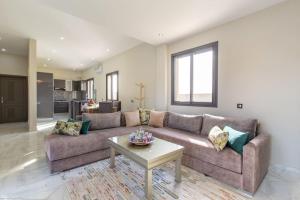 sala de estar con sofá y mesa en Villa Vista , Piscine 22m , Jeux jardins , Terrain squash, en Marrakech