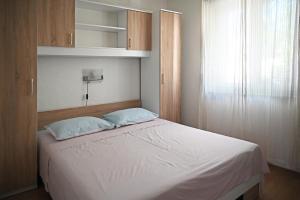 a bedroom with a large white bed and wooden cabinets at Apartments Antica in Vrboska