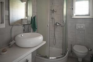 a bathroom with a sink and a shower and a toilet at Apartments Antica in Vrboska +44 photos