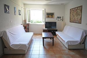 a living room with two white beds and a table at Apartments Antica in Vrboska