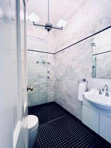 a bathroom with a toilet and a sink at Carrington Hotel in Katoomba