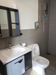W łazience znajduje się umywalka, toaleta i lustro. w obiekcie Utopia Homestay @ Cameron Centrum w mieście Cameron Highlands