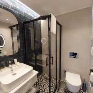een badkamer met een douche, een wastafel en een toilet bij ALESSIA HOTEL & SPA in Side