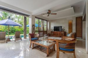 a living room with a table and chairs and a television at Villa Rumah Isah in Candidasa