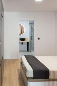 a white bedroom with a bed and a desk at VLC Host - Lleons Cityscape in Valencia