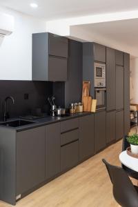a kitchen with black cabinets and stainless steel appliances at VLC Host - Lleons Cityscape in Valencia