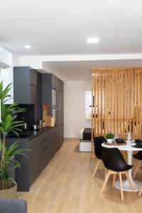 a kitchen with black cabinets and a table and chairs at VLC Host - Lleons Cityscape in Valencia