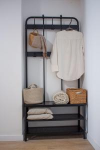 a black iron shelf with towels and baskets on it at VLC Host - Lleons Cityscape in Valencia