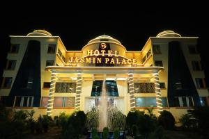 un hotel con una fontana di fronte ad esso di notte di Hotel Jasmin Palace ad Angul