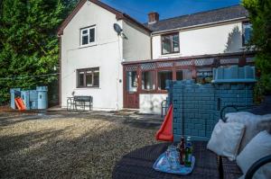 a house with a table in the front yard at Angel Cottage - 3 Bedroom Cottage - Stepaside in Stepaside