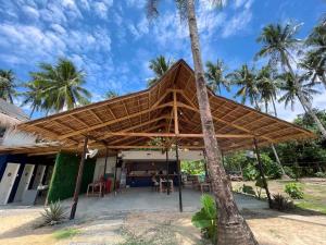 a pavilion with a straw roof on a resort at Dawn Patrol Siargao in General Luna