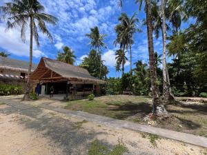 a building with palm trees in front of it at Dawn Patrol Siargao in General Luna