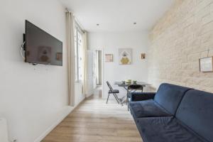 パリにある1022Lenyの青いソファとレンガの壁が備わるリビングルーム