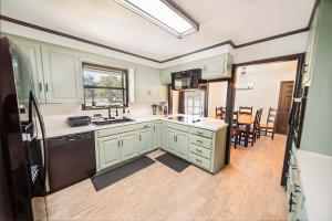 a kitchen with green cabinets and a black refrigerator at Casa on the Cove in Chandler