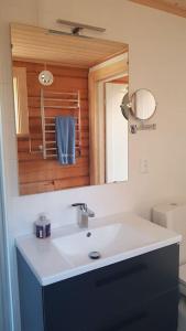 a bathroom with a sink and a mirror at UTSIKTEN -exklusivt nybyggt timmerhus -Plintsberg. in Tällberg